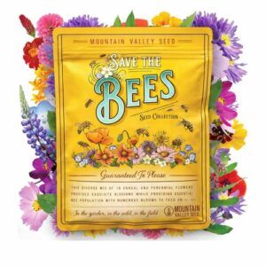 Yellow “Save the Bees” wildflower seed packet surrounded by a colorful mix of blooming flowers, featuring illustrated bees and floral artwork on the front.
